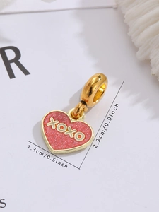 Detailansicht eines goldenen XOXO Herzanhängers in Rosa mit Maßen 1,3 cm x 2,3 cm