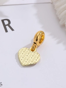 Makro-Detail des goldenen Herzanhängers mit strukturierter Oberfläche für DIY-Schmuck