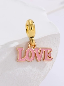 Makroaufnahme von vergoldetem LOVE-Anhänger mit rosa Emaille für DIY-Armbänder