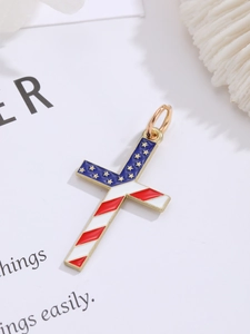 Detail view of gold-plated cross pendant with American flag pattern on a white floral background