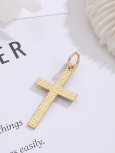 Detailed close-up of a golden cross pendant with textured finish and top jump ring