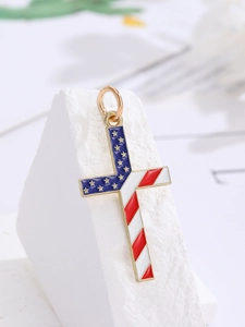 Macro view of a cross pendant with US flag enamel stars and stripes for jewelry making