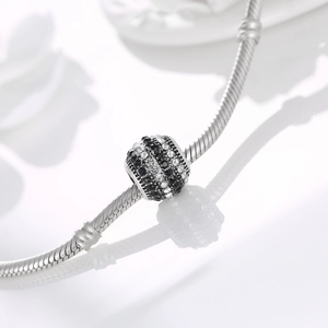 Macro shot of silver charm bead with black and white rhinestones on a snake chain bracelet