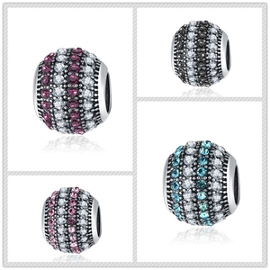 Macro detail of pave-set round zirconia charms in purple, black, pink, and blue colors