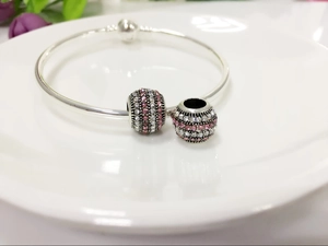 Detailed macro view of pink and white crystal pave charms on a silver plated snake chain