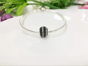 Detail of silver smooth bangle bracelet with black and white crystal pave charm bead