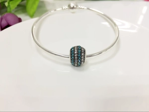 Close-up of silver snake chain bracelet with blue and white pavé crystal slider bead