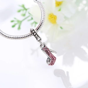 Detailed close-up of a silver snake chain bracelet with a pink crystal high heel pendant