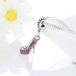Macro view of silver stiletto charm featuring pink rhinestones on snake chain bracelet