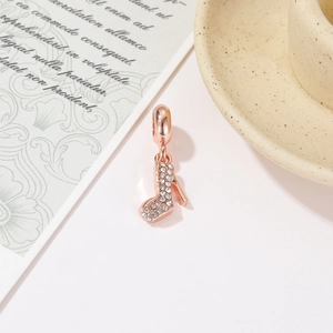 Elegant rose gold high heel pendant with sparkling crystals on a vintage background