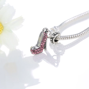 Detail of high heel pendant with pink rhinestones on a silver snake chain bracelet