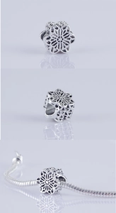 Vista macro de dijes de flores caladas en plata retro para pulseras hechas a mano