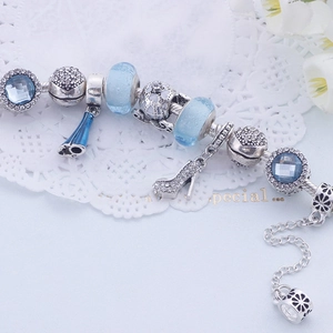 Gros plan sur un bracelet en argent perlé avec des perles bleues et charms de carrosse