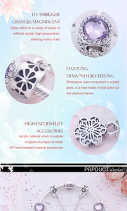 Detailed macro view of hollow flower metal charm with purple crystal and white rhinestones