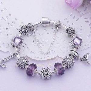 Vue détaillée des perles en cristal violet et charms fleurs sur une chaîne serpent argentée