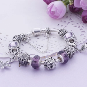 Vue détaillée des perles de verre violettes et pendentifs flocon sur un bracelet argent