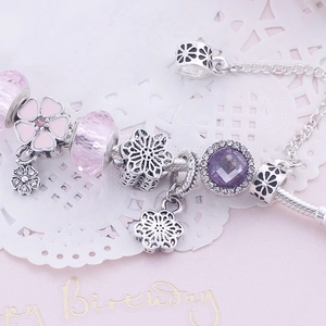 Detail showing pink crystal beads, enamel floral charms and sparkling snowflake pendants