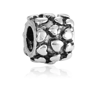 Detalle de una cuenta de plata vintage con diseño de corazones para joyería artesanal