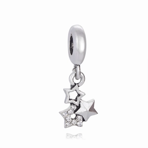 Macro shot of silver triple star charms with sparkling cubic zirconia on white base