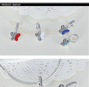 Detailed macro view of colorful enamel butterfly pendants and silver beaded bracelet charms