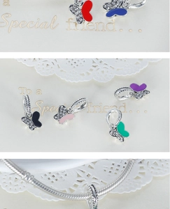 Close-up of colorful enamel butterfly charms with sparkling crystals on a silver chain
