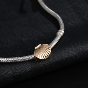 Golden seashell pendant on silver snake chain bracelet, elegant beach style jewelry