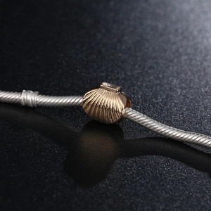 Golden shell charm on silver snake chain bracelet with sparkling zircon stones