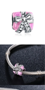 Macro shot of pink enamel gift box charm with sparkling rhinestone bow for bracelets
