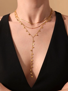 Detailed layered golden necklace featuring a snake chain, beads, and Y-shaped sequin fringe