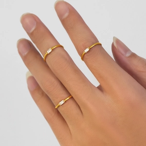 Three thin 18K gold plated stainless steel rings with rectangular zircon stones on hand