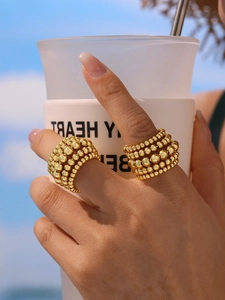 Detailed close-up of multi-layer gold beaded wide band ring in 18K plated finish