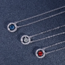 Detail view of round sparkling pendant necklaces in blue, red and white gems