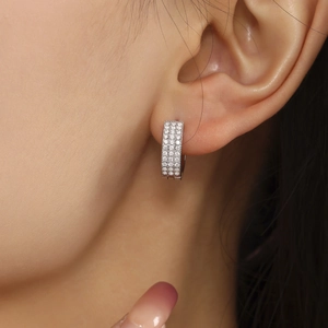 Orecchini huggie color argento lucido con tre file di pietre di zirconia cubica