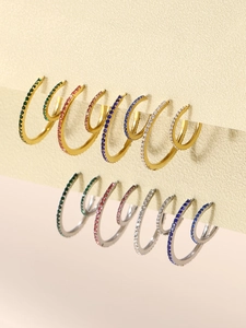 Close-up of hoop earrings with colorful zircon stones in gold and silver finish