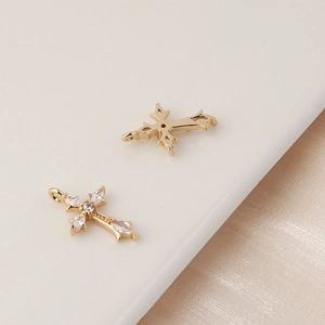 Macro detail of gold-plated cross pendants with cubic zirconia and filigree backings