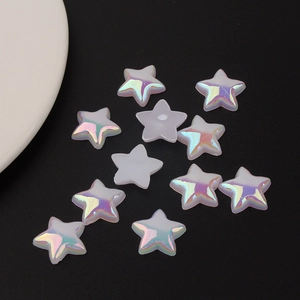 Macro detail of iridescent pearl star-shaped acrylic beads for DIY crafting on black background