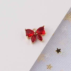 Vista macro de colgante de mariposa chapado en oro con circonitas rojas y aro de enganche