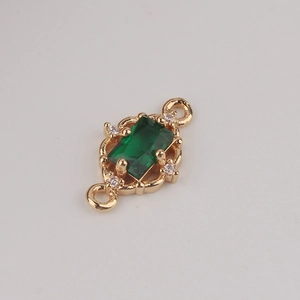 Macro detail of rectangle emerald zircon connector with gold frame and double hanging loops