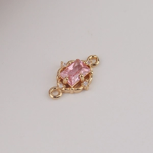 Macro shot of gold-plated pendant with pink rectangular zircon and hollow metalwork