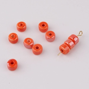 Macro shot of orange glazed ceramic donut beads with smooth finish for DIY jewelry crafts