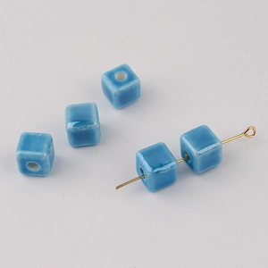 Macro shot of sky blue cube ceramic beads with vertical holes for DIY jewelry making