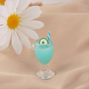 Dettaglio di un calice in miniatura con bevanda blu alla frutta, avocado e cannuccia