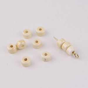 Detail of cream ceramic abacus beads showing texture and hole for jewelry DIY crafts