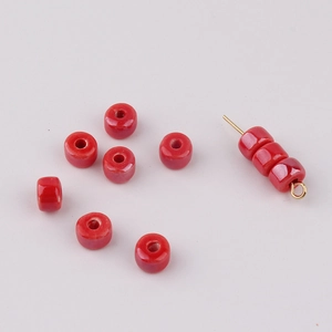 Macro shot of glossy red ceramic abacus beads with central holes for DIY jewelry making