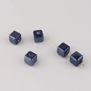 Macro view of dark blue square ceramic cube beads with holes for DIY jewelry making