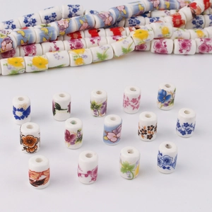 Detailed view of cylindrical ceramic floral beads with various colorful patterns for DIY jewelry