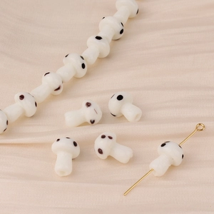 Detailed macro view of handmade white glass mushroom beads for DIY jewelry crafting