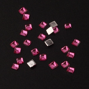 Detailed close-up of 2mm square rose red acrylic rhinestones with silver flat back base