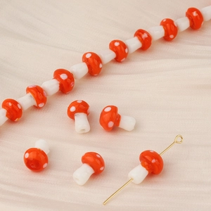 Macro detail of red and white mushroom lampwork glass beads for handmade jewelry DIY