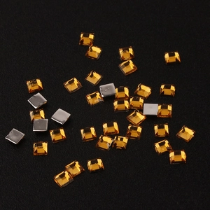 Macro shot of 2mm amber square acrylic rhinestones with flat silver foil backing for nail art